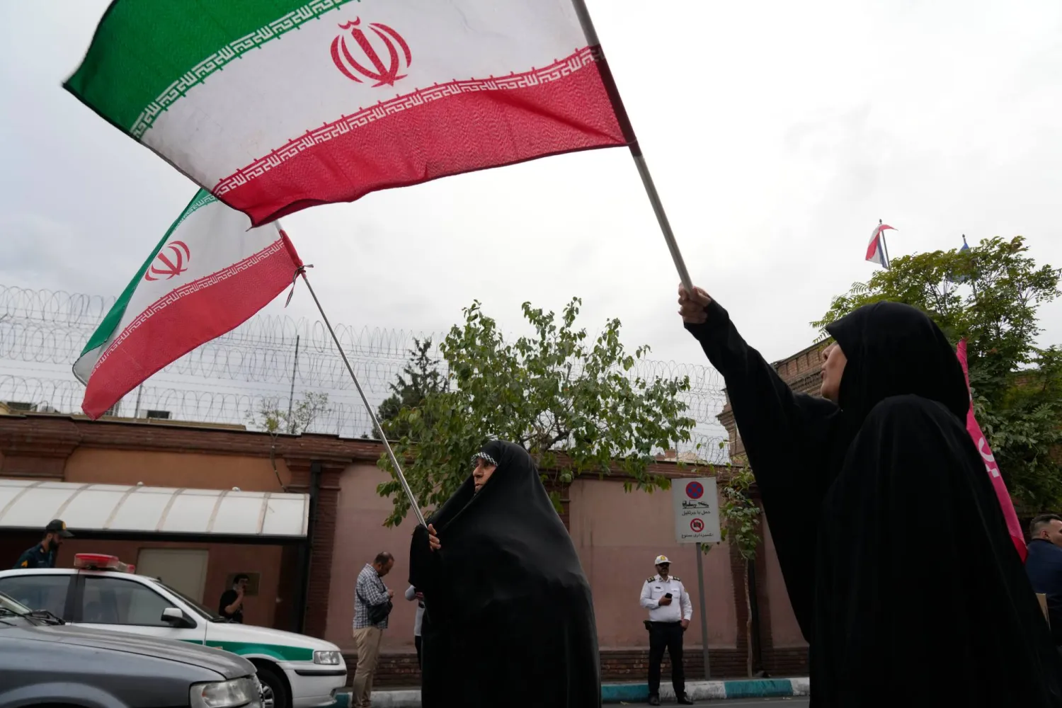  Iranian women hold their country's flags during a protest to condemn France's "violent crackdown on students demonstrations and human rights violations" in front of the French Embassy in Tehran, Iran, Saturday, Oct. 10, 2026. (AP) 
