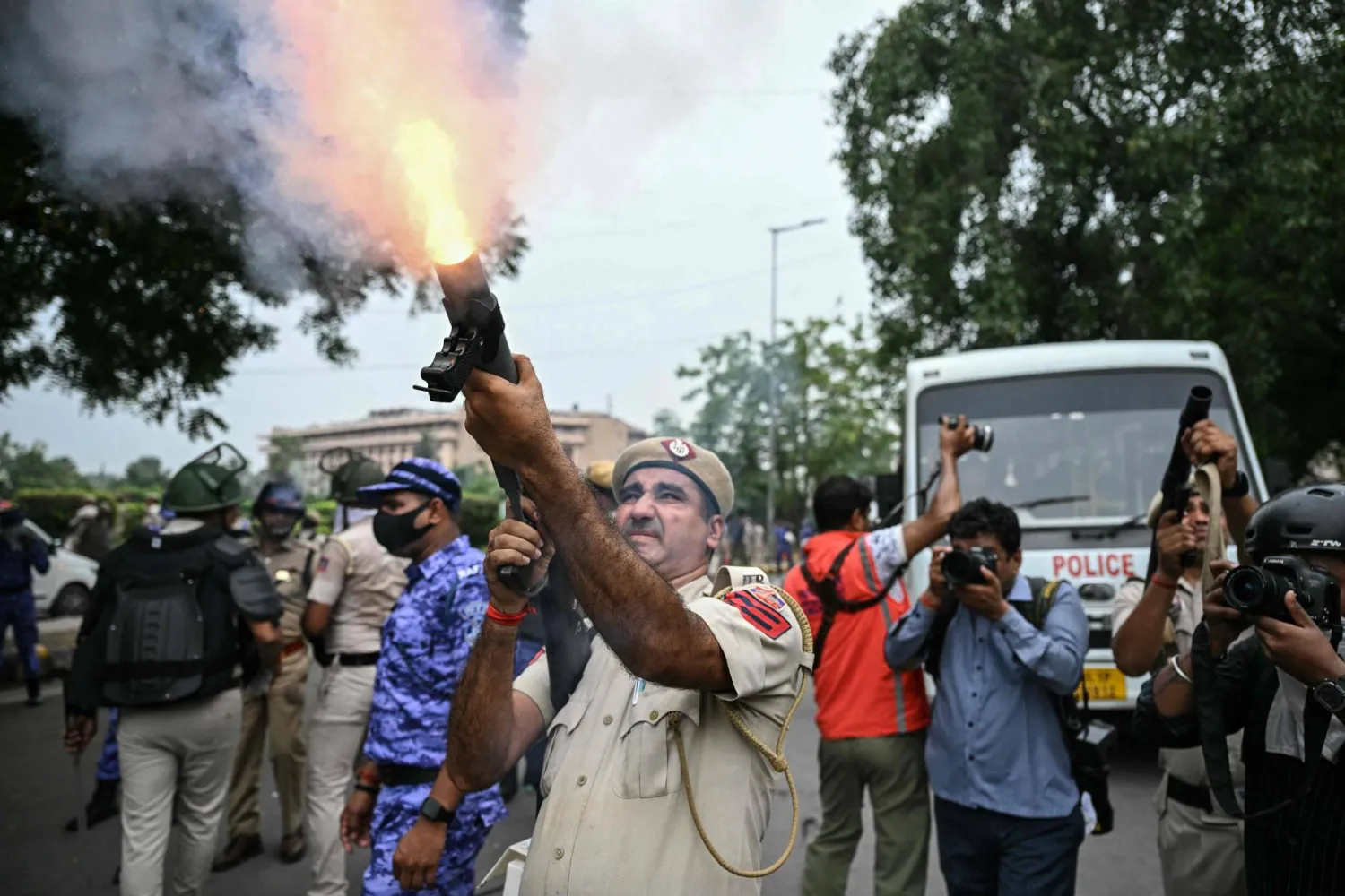 (FILES) A police personnel fires tear gas shells to disperse activists and supporters of the Cockroach Janta Party (CJP) during a protest demanding the resignation of India's Education Minister Dharmendra Pradhan over alleged NEET examination irregularities in New Delhi on July 20, 2026. (Photo by Sajjad HUSSAIN / AFP)