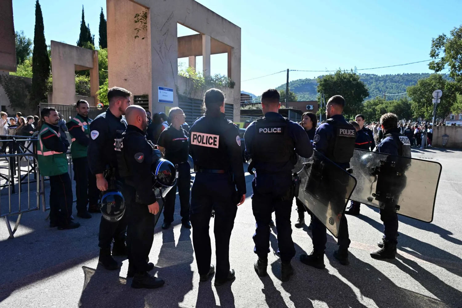 Policemen stand in front of Joseph-Lakanal high school after a headmaster was injured by a hunting rifle shot and a teenager was arrested in Aubagne, southern France, on October 12, 2026. (Photo by Miguel MEDINA / AFP)
