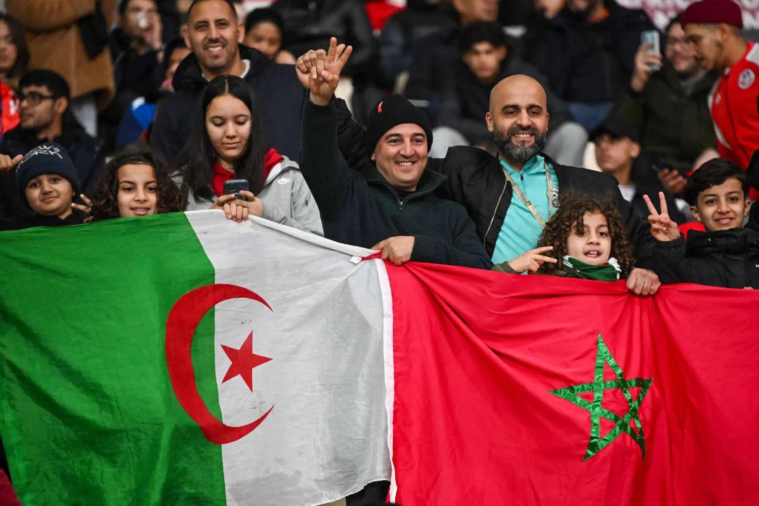 جماهير ترفع العلمين المغربي والجزائري (أ.ف.ب)