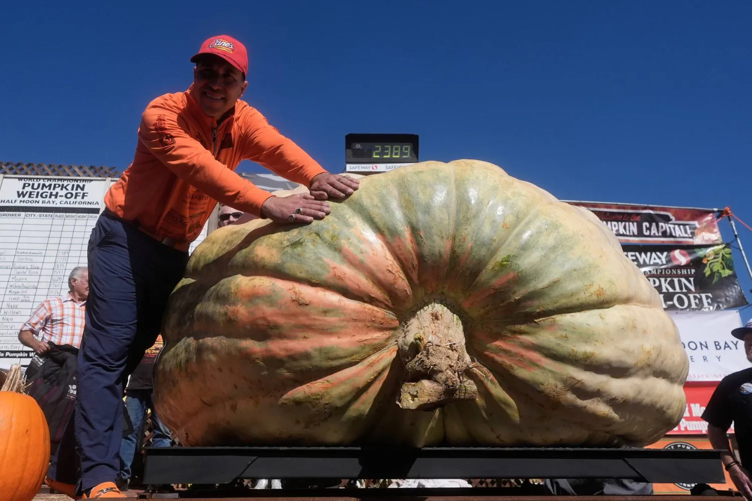 Travis Gienger, of Anoka, Minn., poses for photos with his pumpkin that won first place at the Safeway World Championship Pumpkin Weigh-Off, Monday, Oct. 12, 2026, in Half Moon Bay, Calif. (AP) 
