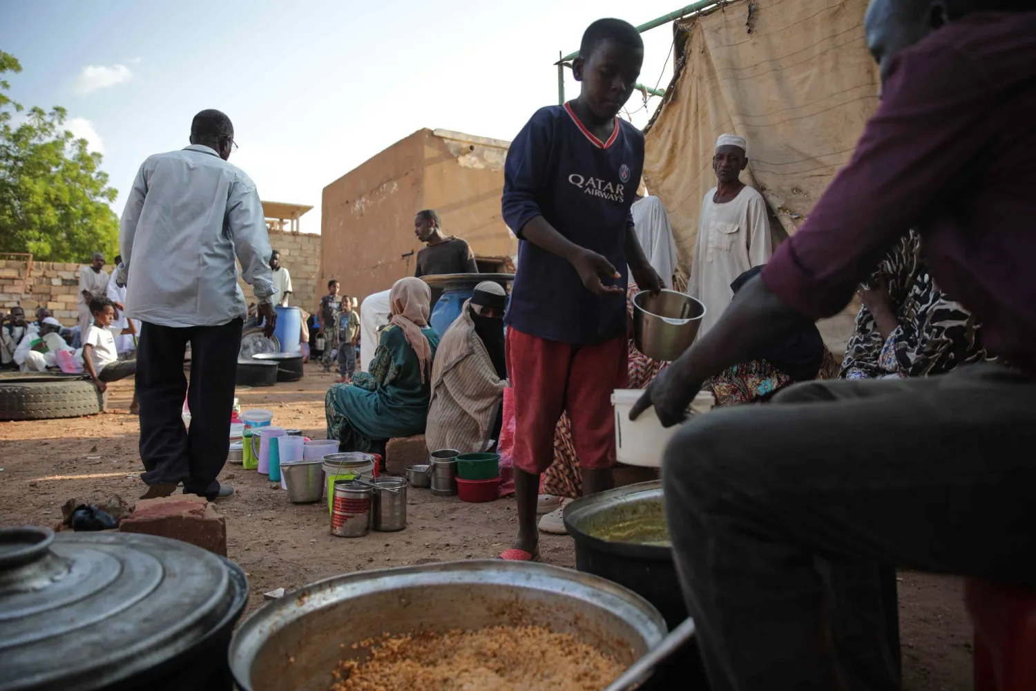 فتى سوداني يمسك وعاء للحصول على طعام من مطبخ خيري بالخرطوم 23 سبتمبر الماضي (أ.ب)