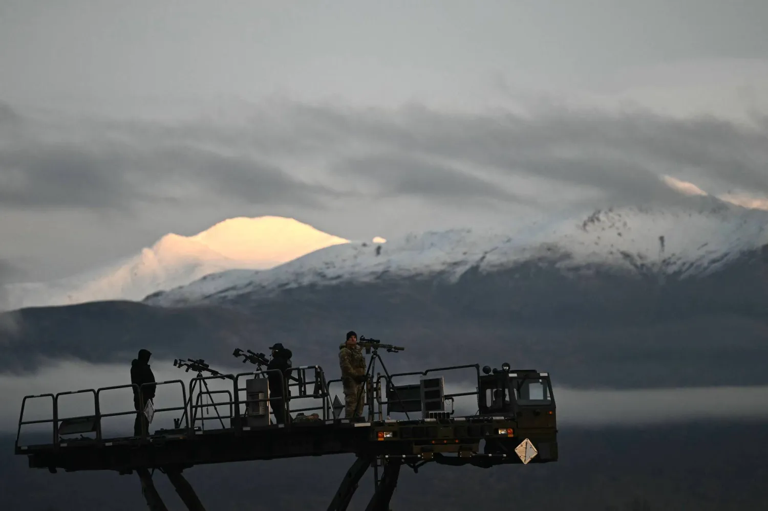 A snipers team provides security as US President Donald Trump boards Air Force One at Elmendorf Air Force Base in Anchorage, Alaska, on October 13, 2026. (Photo by Kent NISHIMURA / AFP)