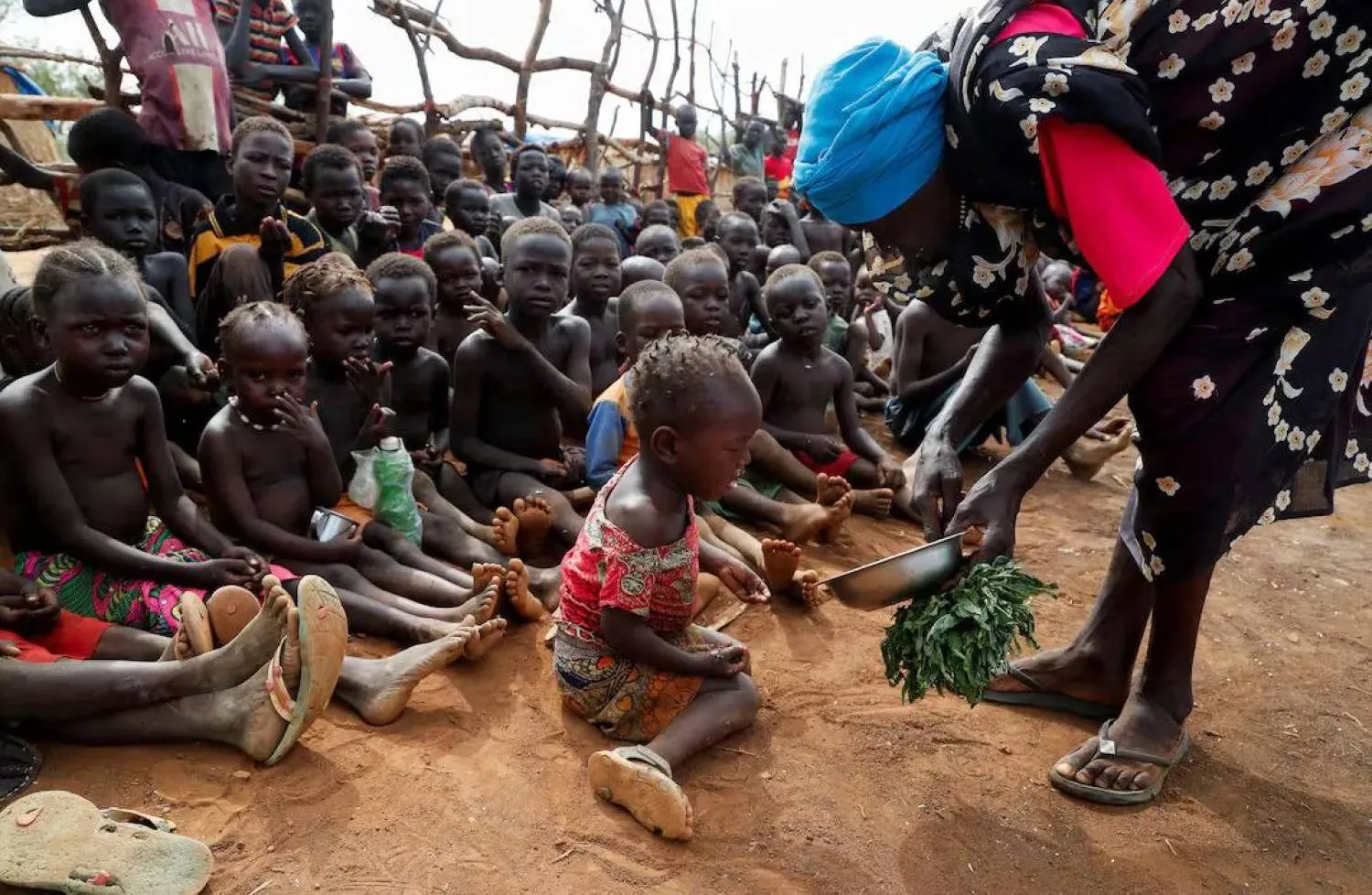 تقديم طعام للأطفال الأيتام في مخيم بروام للنازحين داخلياً بجنوب كردفان بالسودان 22 يونيو 2024 (رويترز)