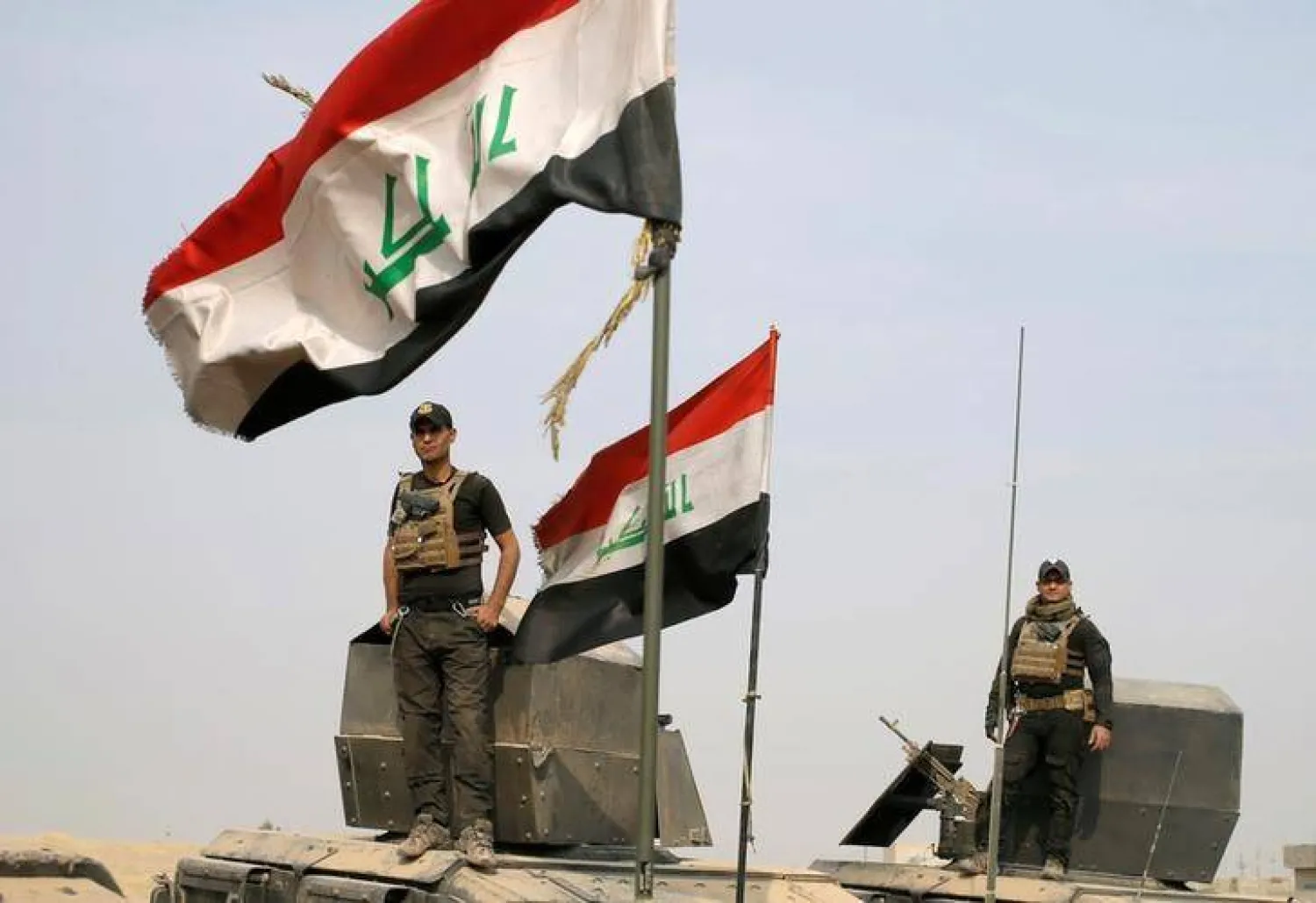 جنود من القوات الخاصة العراقية يقفون فوق مركبات مدرعة في قرية قرب الموصل بالعراق يوم 25 أكتوبر 2016 (رويترز)