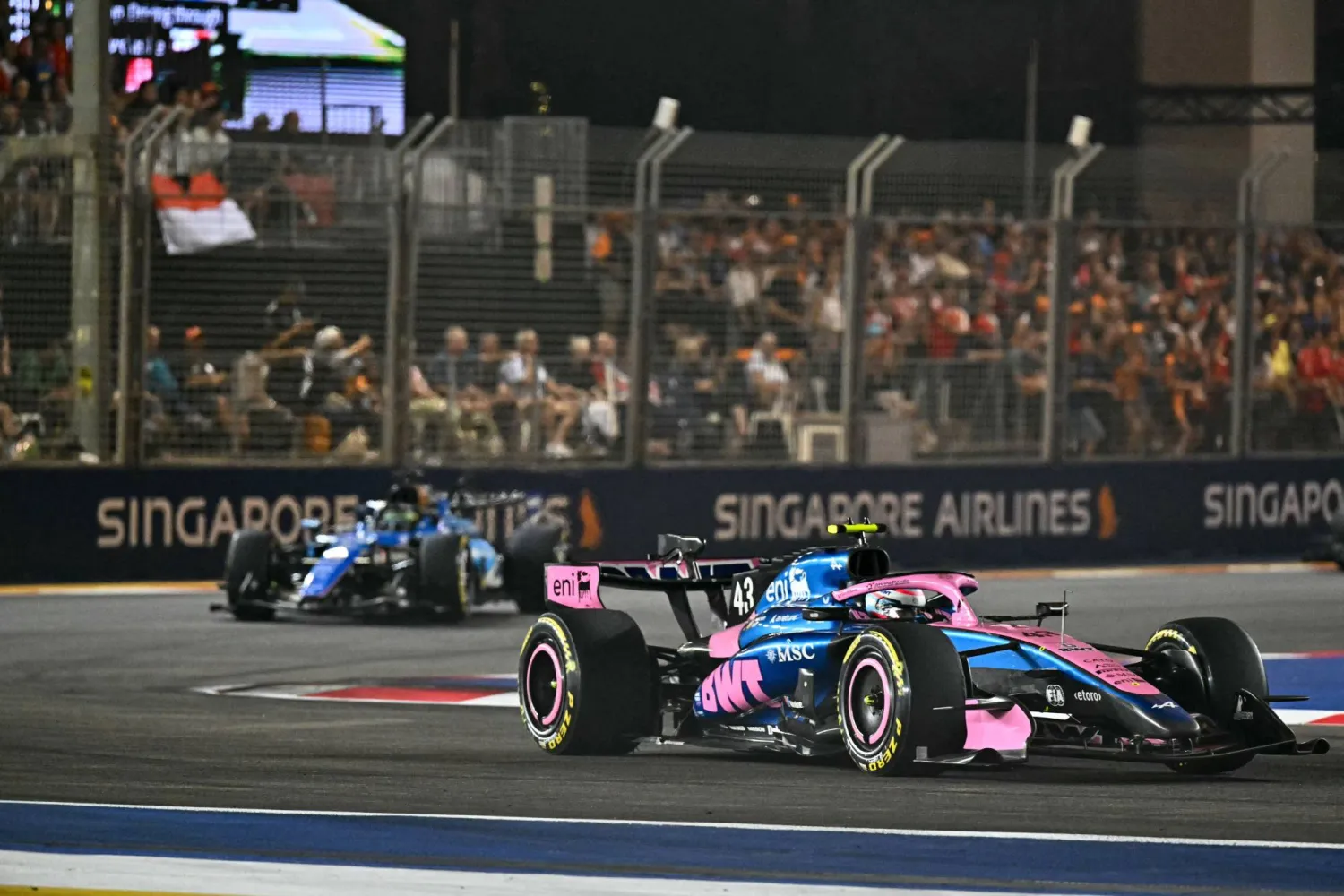 Alpine's Argentine driver Franco Colapinto (R) drives in front of Williams' Thai driver Alexander Albon during the Formula One Singapore Grand Prix at the Marina Bay Street Circuit in Singapore on October 11, 2026. (Photo by Lillian SUWANRUMPHA / AFP)