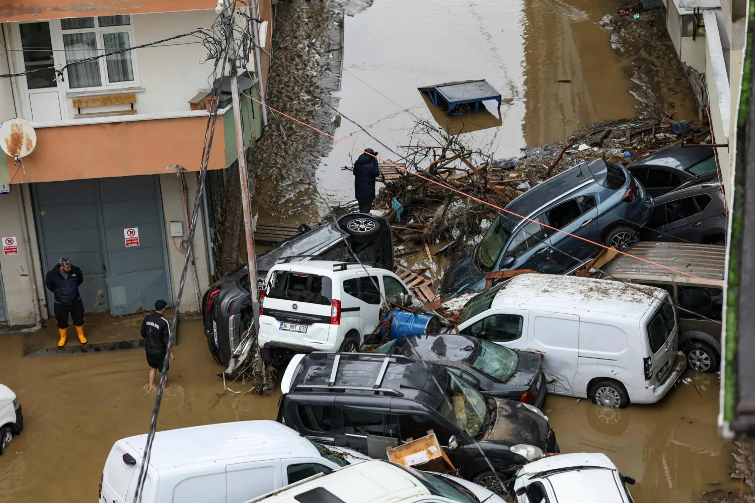 Car owners search for their vehicles swept away by the flood after a heavy rain at Ayazaga district in Istanbul, on October 15,2026. (AFP)