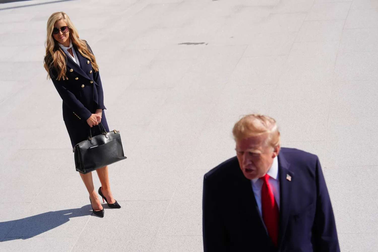 President Donald Trump speaks to the reporters as he walks to board Marine One on the South Lawn of the White House, Tuesday, Oct. 13, 2026, in Washington, as White House press secretary Katie Zacharia looks on. (AP Photo/Julia Demaree Nikhinson)