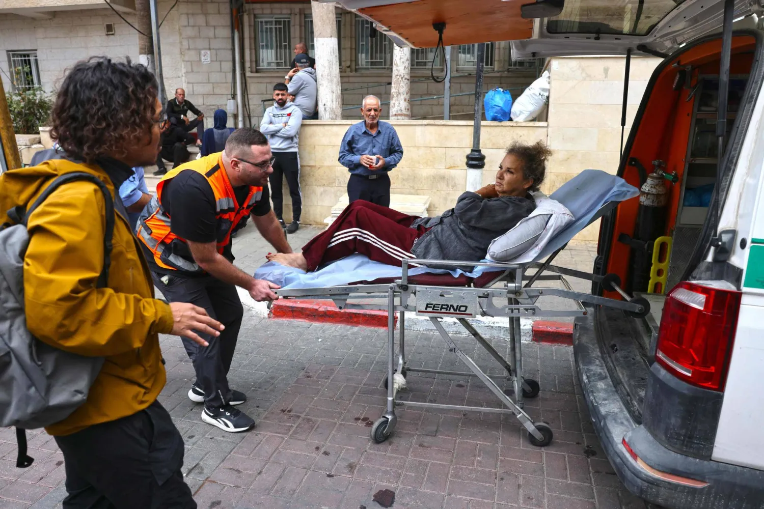 نقل المصورة الصحافية الأميركية هايدي ليفين إلى سيارة إسعاف فلسطينية بعد الاعتداء عليها في الضفة الغربية (أ.ف.ب)