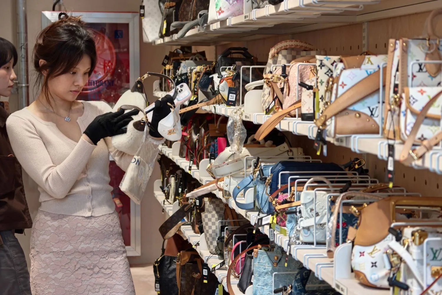 This picture taken on October 14, 2026 shows a customer browsing purses among secondhand luxury goods at the Zhuanzhuan superstore in the Jing'an District in Shanghai. (Photo by Pedro PARDO / AFP) 