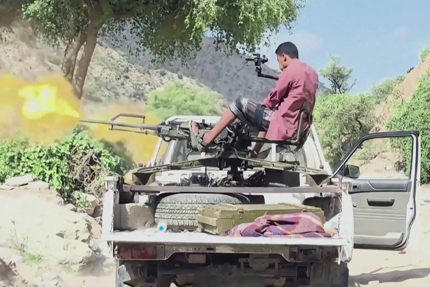 This frame grab taken on October 9, 2026, from AFPTV video footage shows a member of the Yemeni government forces firing a machine gun mounted on a pick-up truck during clashes with Houthi fighters in Hayfan district, south of Taiz, on October 8, 2026. (AFPTV /AFP) 