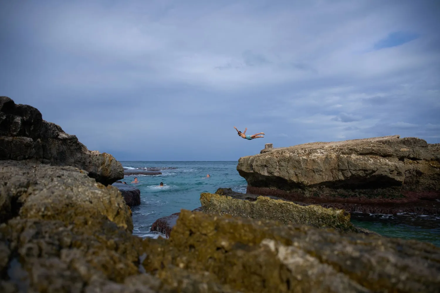 A boy jumps off a rock into the Mediterranean Sea in Beirut, Lebanon, Saturday, Oct. 17, 2026. (AP Photo/Hassan Ammar)