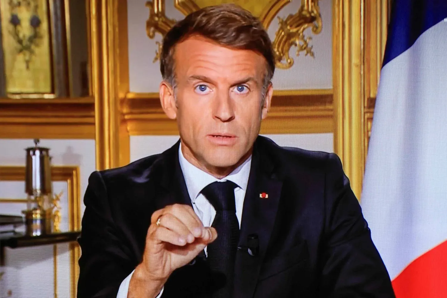 Fransa Cumhurbaşkanı Emmanuel Macron’un, Paris’teki Élysée Sarayı’ndan yaptığı konuşmanın televizyonda yayımlanan görüntüsü. (AFP)