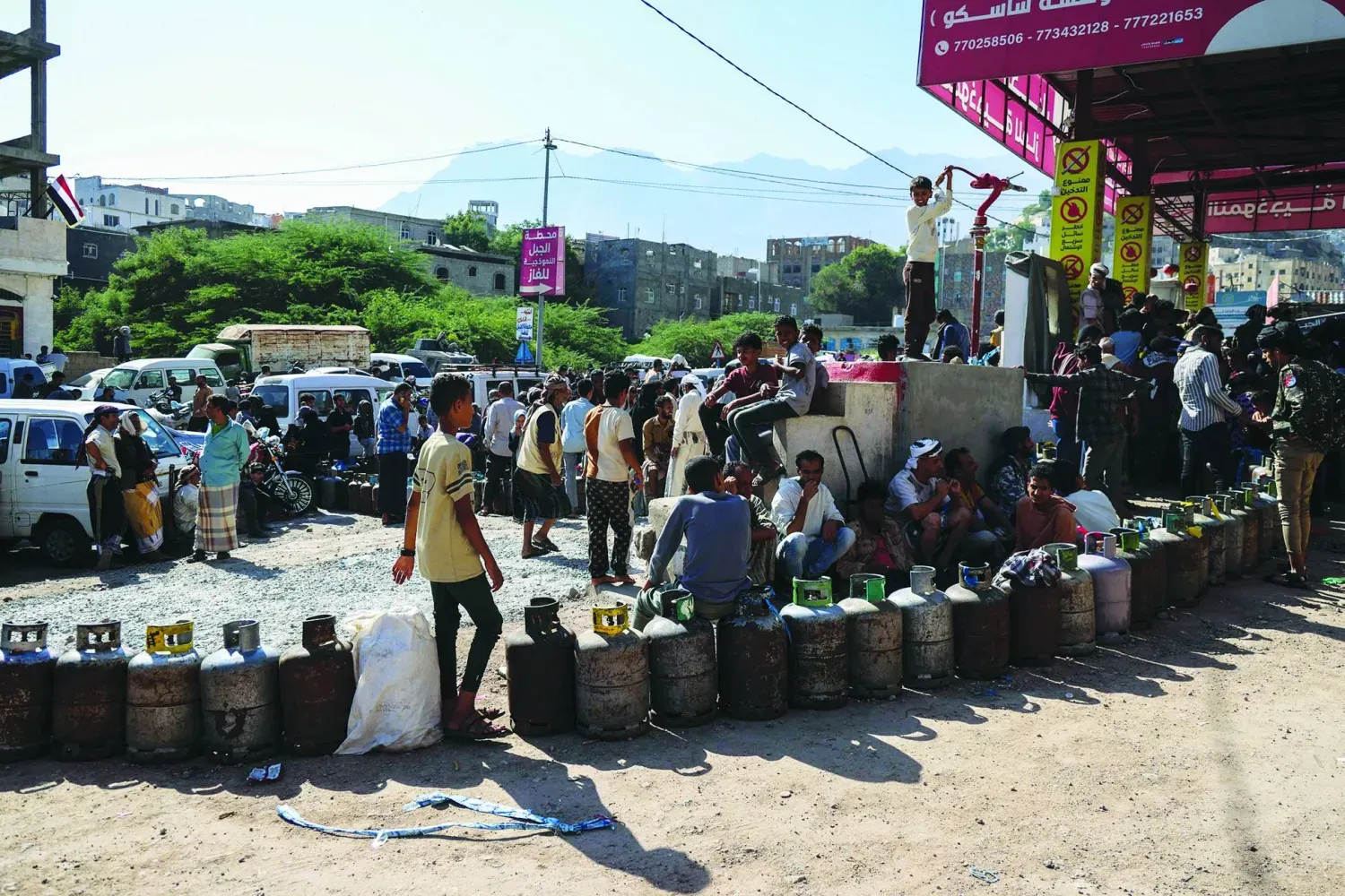 Yemenliler, dün Taiz kentindeki bir istasyonda gaz tüplerini doldurmak için sıraya girdi. (AFP)