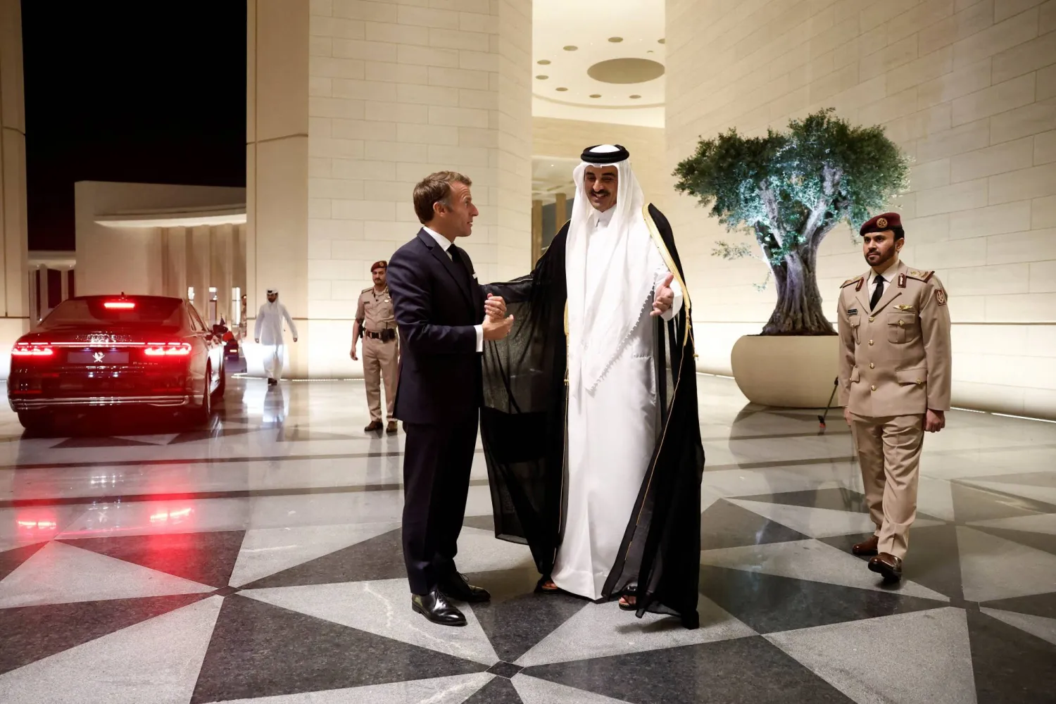 أمير قطر الشيخ تميم بن حمد مستقبلاً الرئيس الفرنسي إيمانويل ماكرون في قصر لوسيل الثلاثاء (رويترز)