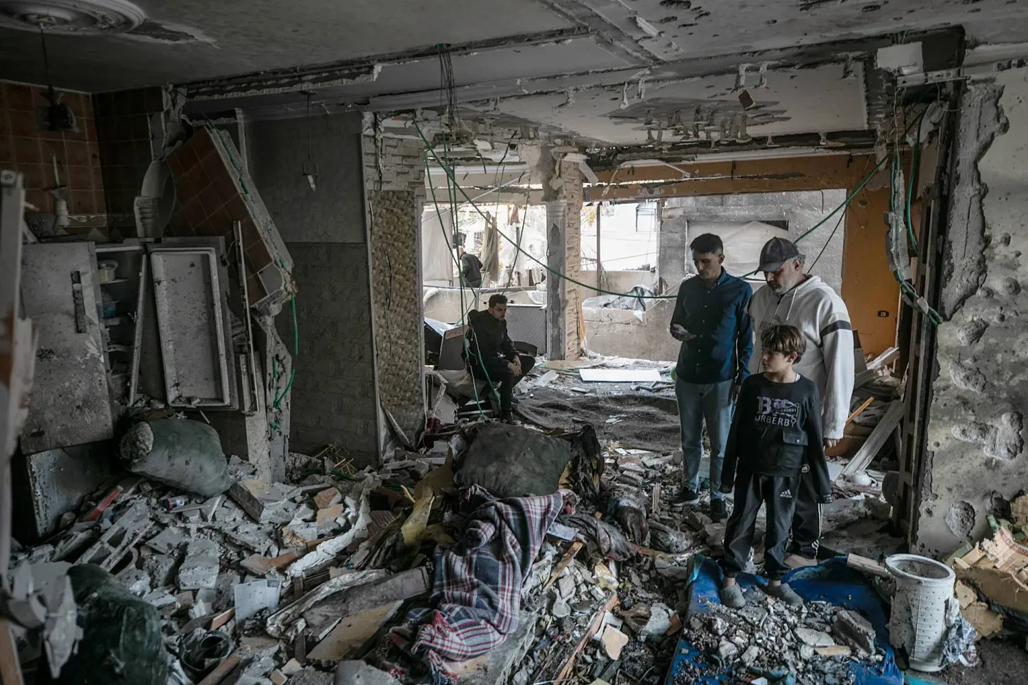 Filistinliler, 20 Ekim 2026'da Gazze kentinin batısında düzenlenen İsrail hava saldırısında yıkılan bir evi inceliyor. (AP)