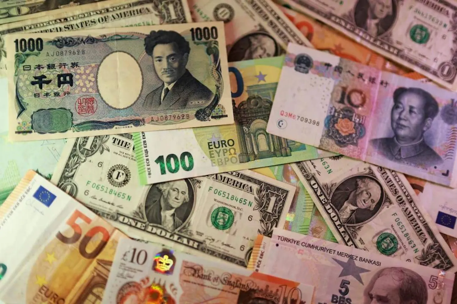 أوراق نقدية من الدولار الأميركي واليورو والين والجنيه الإسترليني والليرة التركية واليوان الصيني (رويترز)