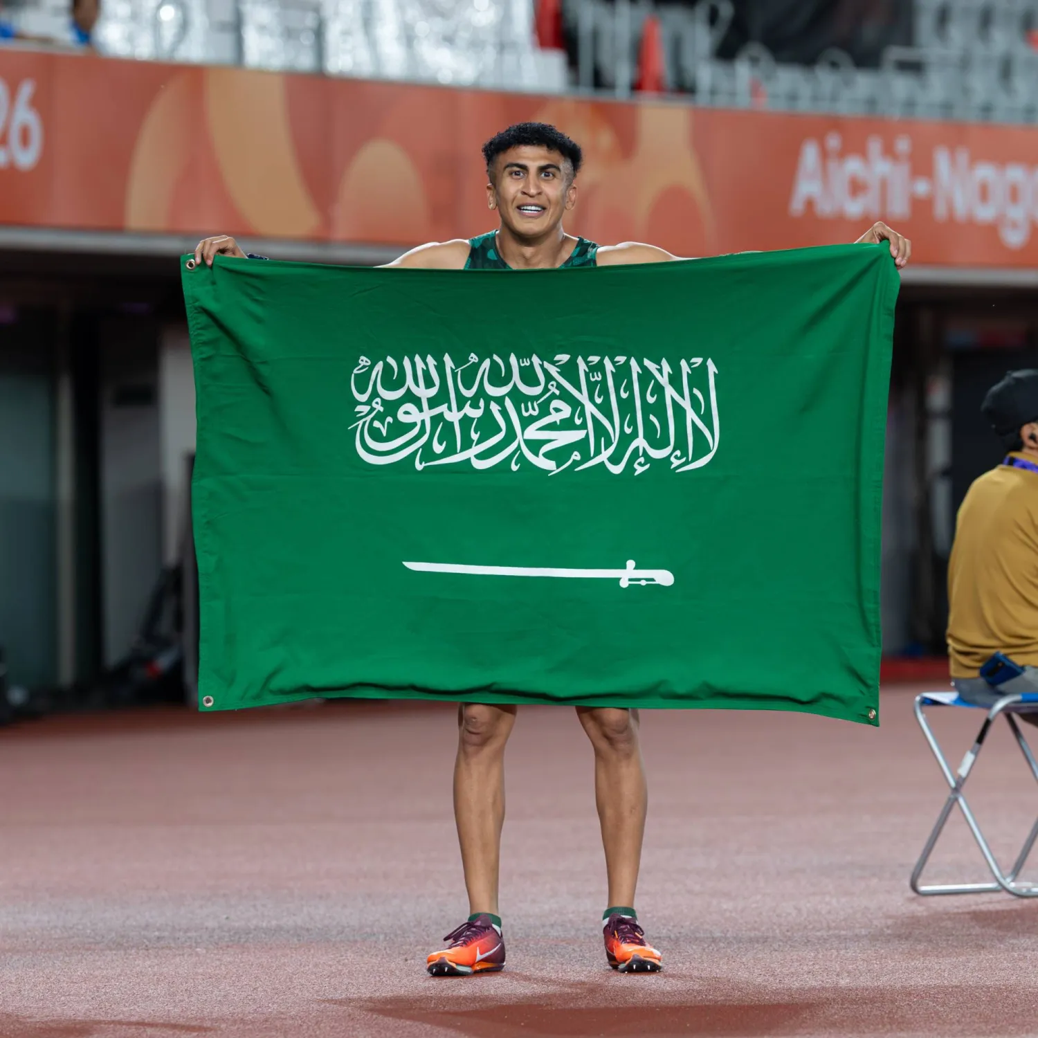 السعودي ثامر الزهراني حاملاً علم بلاده ومحتفلاً بالإنجاز (فريق السعودية)