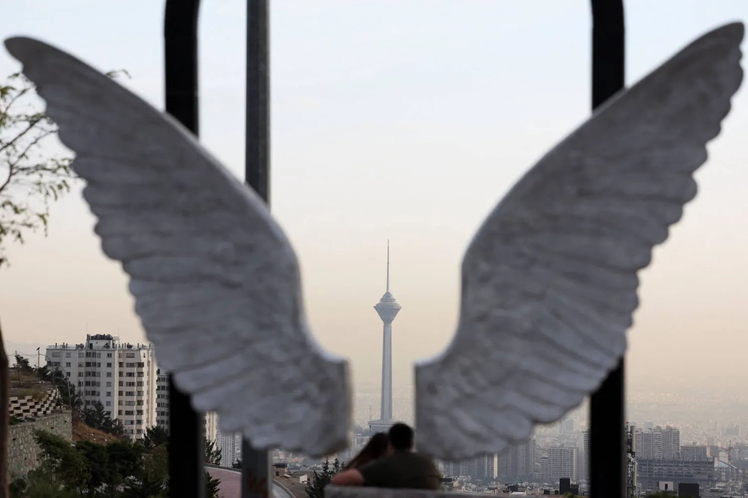 إيرانيون في إحدى حدائق طهران ويظهر برج ميلاد في الخلفية 6 أكتوبر 2026 (رويترز)
