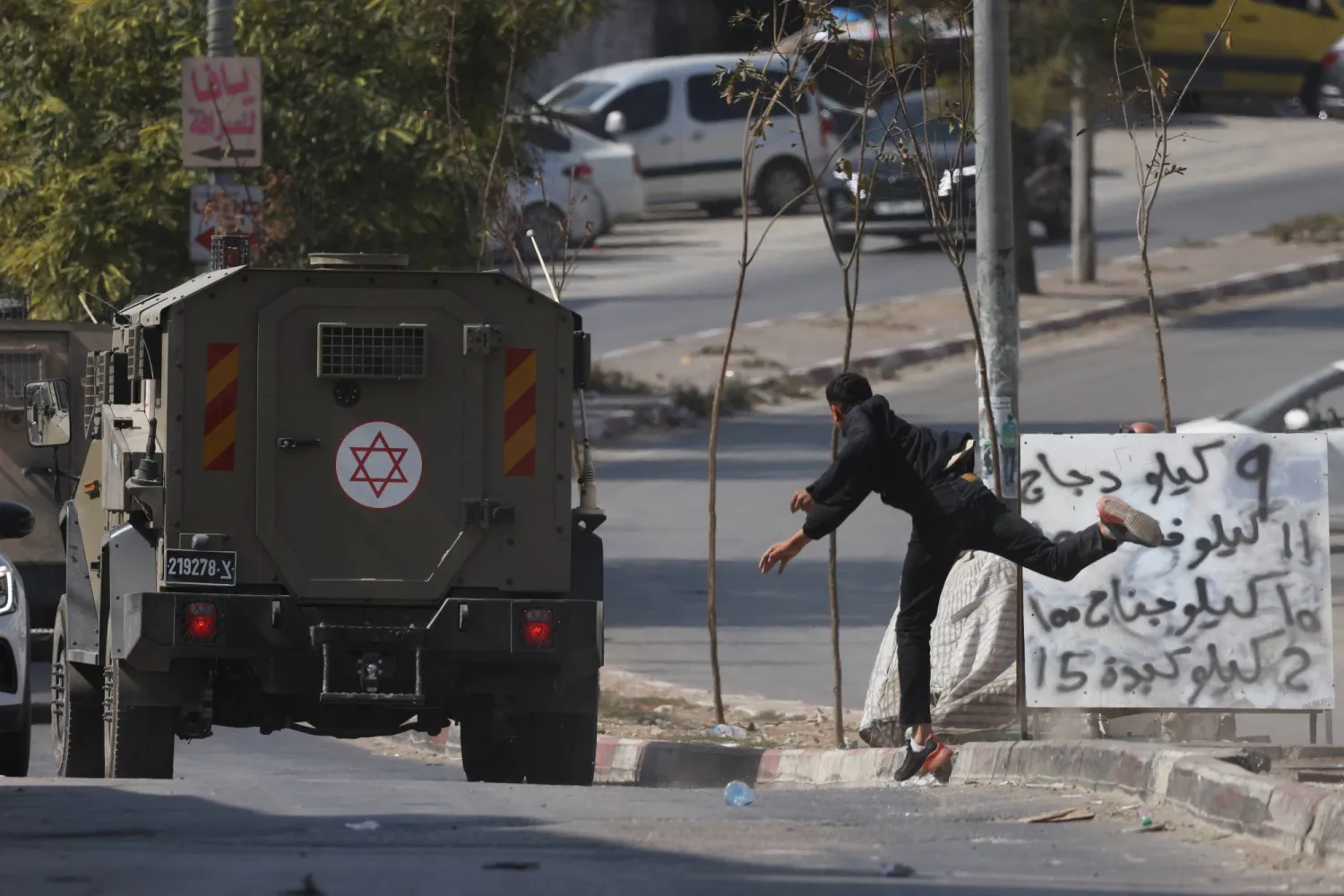  A Palestinian boy throws stones at Israeli troops during an Israeli army raid at Balata refugee camp near the West Bank city of Nablus, 21 October 2026.   EPA/ALAA BADARNEH