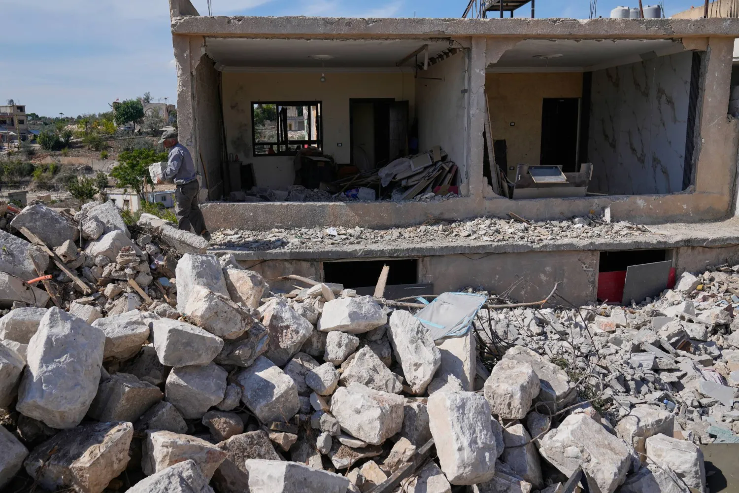A man removes debris from his destroyed house, in Zawtar al-Gharbiyeh village, southern Lebanon, Tuesday, Oct. 20, 2026. (AP)