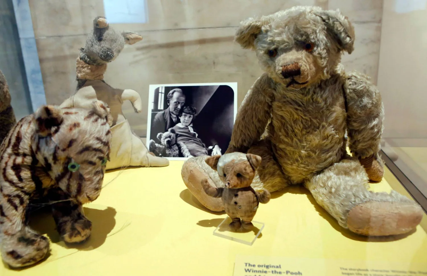 FILE - A photograph of author A. A. Milne with his son Christopher Robin is displayed beside Milne's son Christopher Robin's beloved teddy bear, the inspiration for "Winne-the-Pooh," at the New York Public Library, Monday, Sept. 30, 2013, in New York. (AP Photo/Kathy Willens,File)