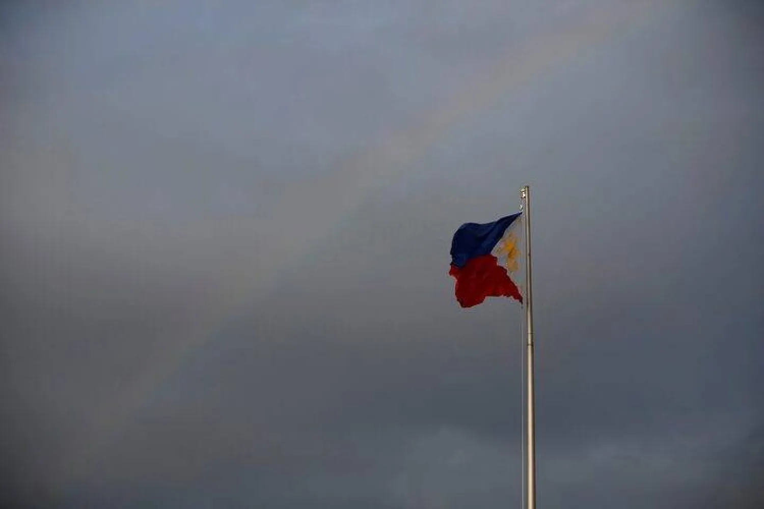 Philippines National Flag is pictured as the rainbow displays over it in Manila, Philippines, January 8, 2020. REUTERS/Willy Kurniawan/File Photo