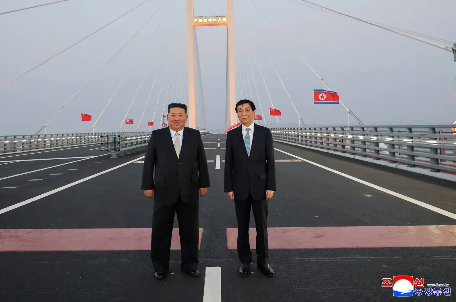 Kuzey Kore lideri Kim Jong-un ve Çin Halk Siyasi Danışma Konferansı Başkanı Wang Huning, iki ülkeyi birbirine bağlayan köprü üzerinde. (Reuters)