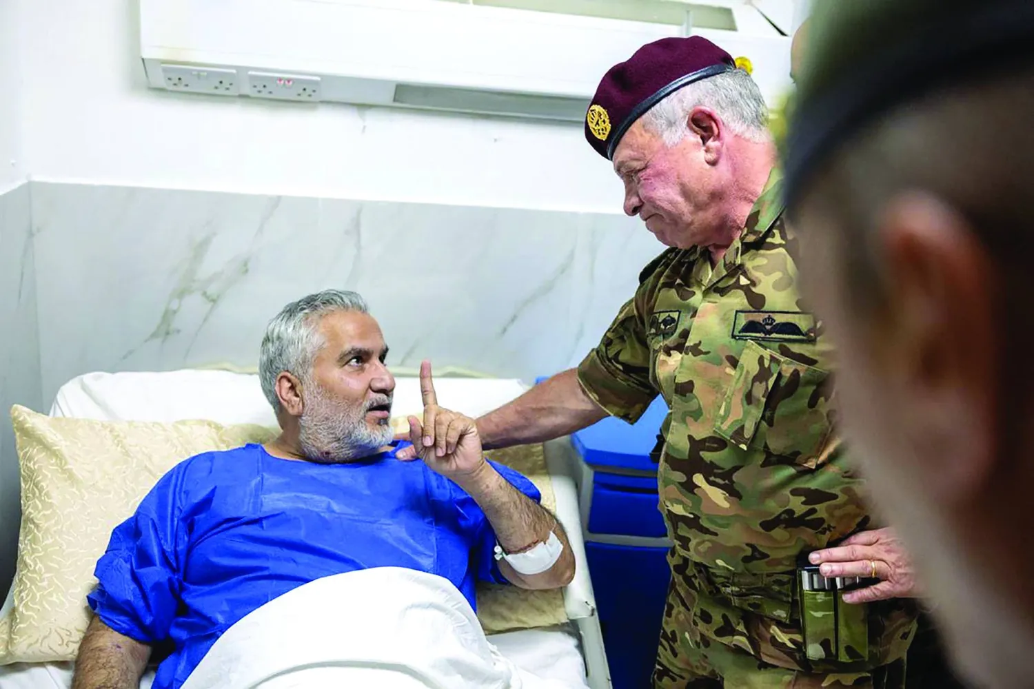 This handout picture released by the Jordanian Royal Palace on October 23, 2026, shows Jordan's King Abdullah II (R) visiting Prince Ali Military Hospital in Karak to check on those who were injured in the attack on a Greek Orthodox church in the village of Hammoud in Karak governorate. (Photo by Jordanian Royal Hashemite Court (RHC) / AFP) 