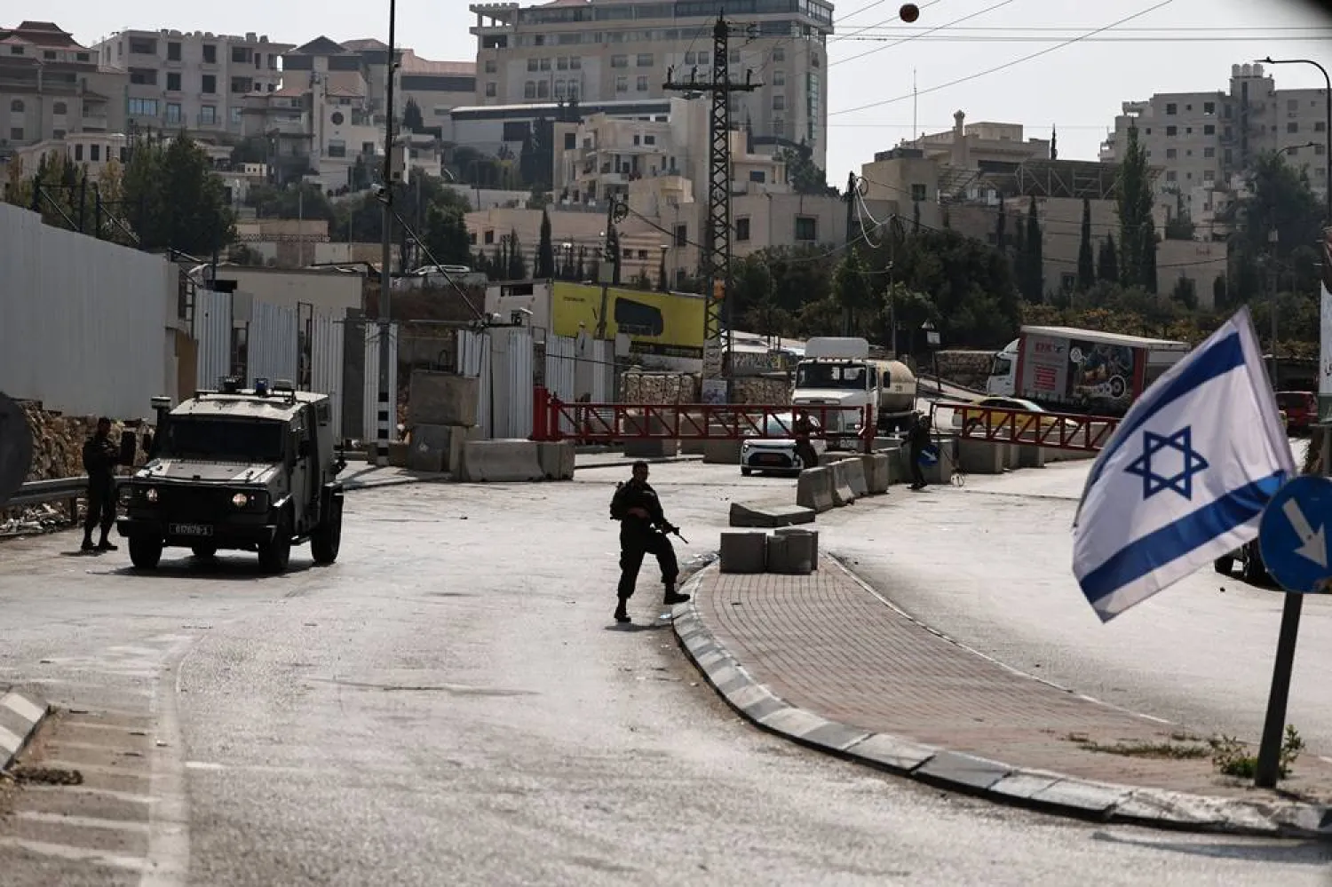 Israeli soldiers stand guard at a closed military gate at an entrance to the West Bank city of Hebron, 25 October 2026, as the military enforced a closure on the city and surrounding villages for a third consecutive day. (EPA)