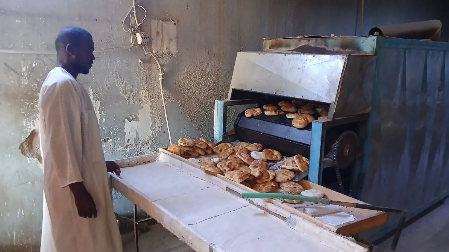 A worker oversees bread production at a bakery in Omdurman (Asharq Al-Awsat)