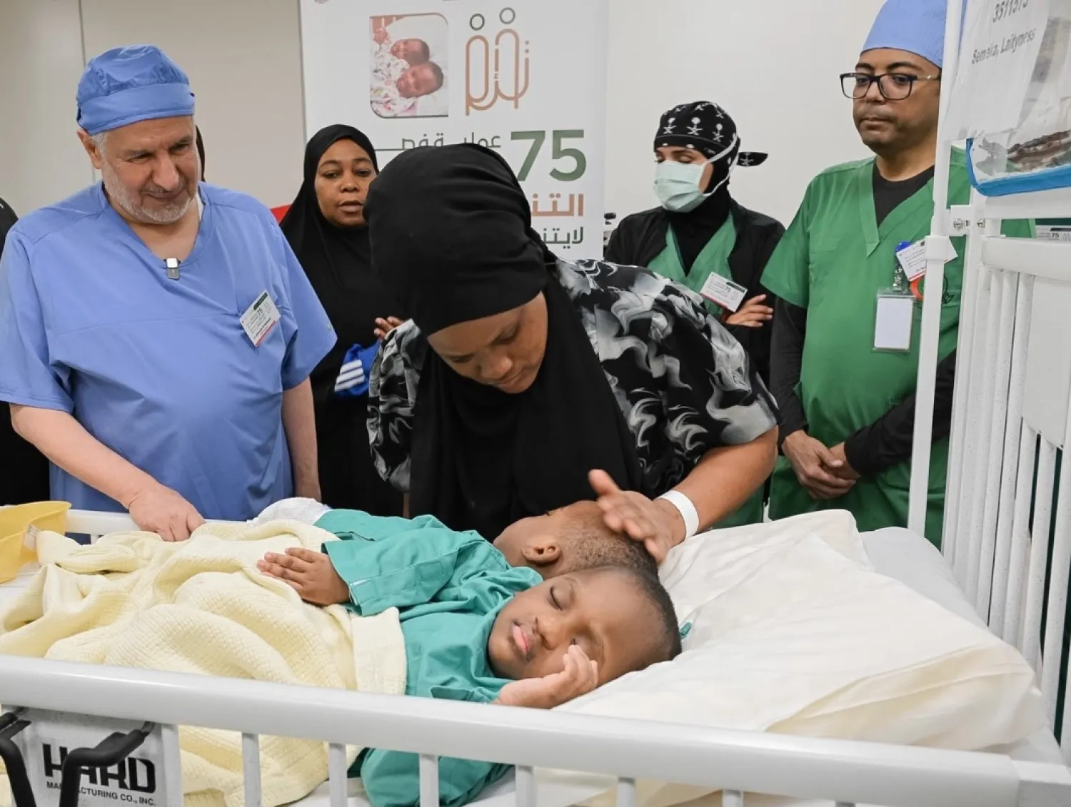 د. عبد الله الربيعة يطمئن على التوأم الملتصق التنزاني «لايتيينس ولوفنس» قبل بدء العملية (واس)