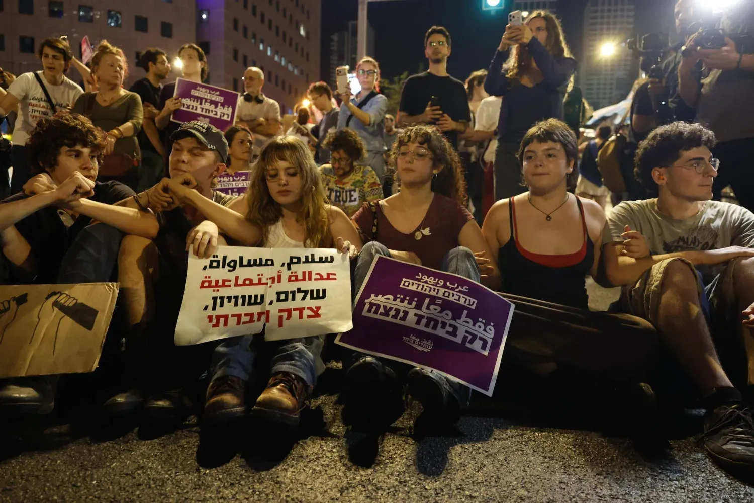 İsrail'in Tel Aviv kentinde, Arap partilerinin de katılımıyla bir hükümet kurulması çağrısıyla düzenlenen yürüyüş sırasında pankart taşıyan sol aktivistler (28 Ekim 2026, DPA)