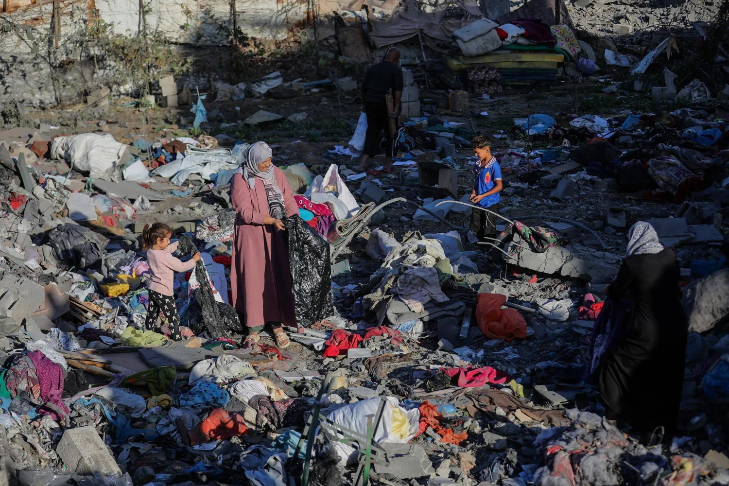 Palestinians stand amid the rubble of their home, destroyed by an Israeli strike in Bureij refugee camp on Friday (DPA). 