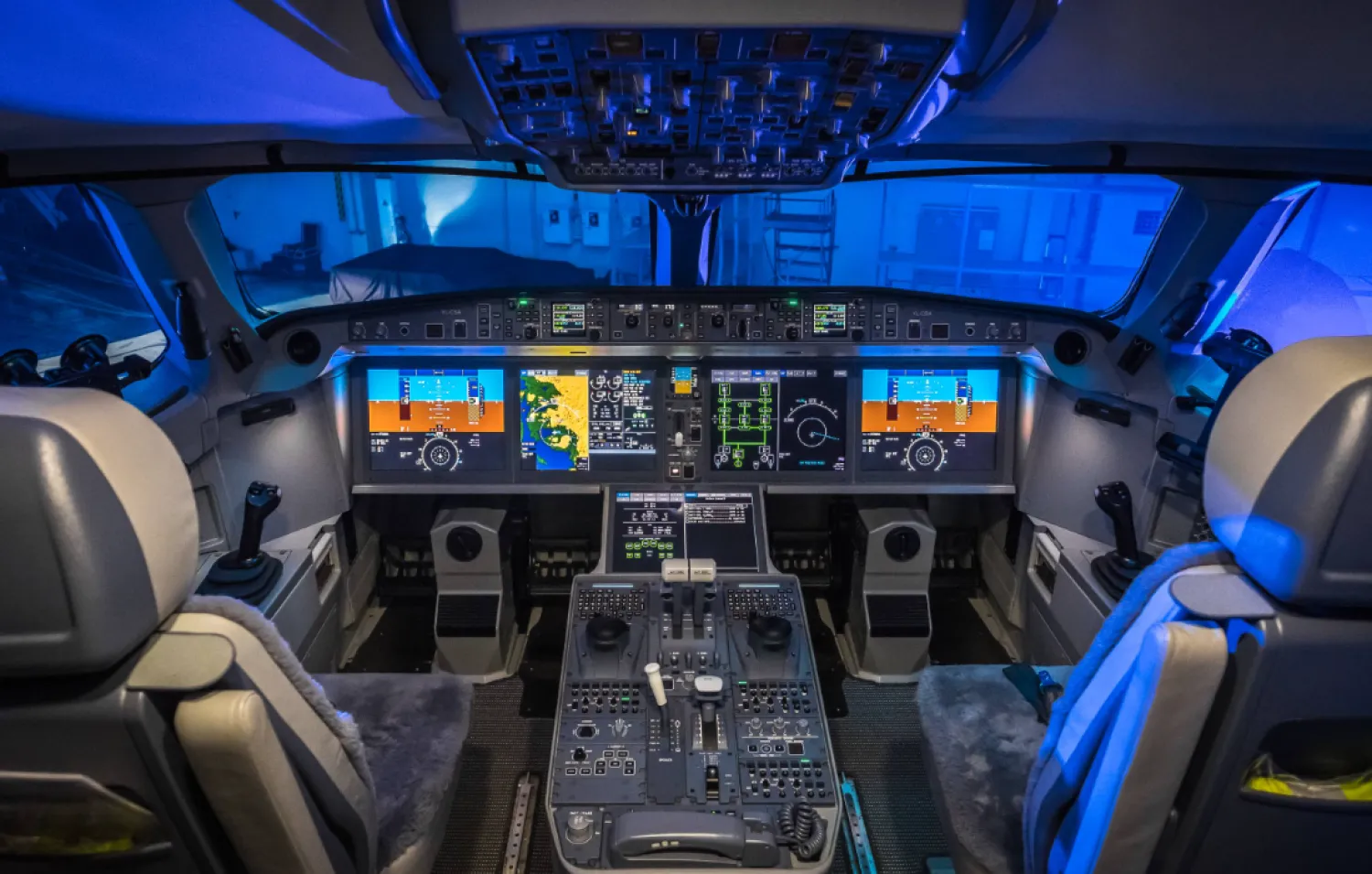 An illustration showing the layout of a modern glass cockpit, with advanced digital displays and the center pedestal located between the captain's and first officer's seats. The transponder used by pilots to enter the three-digit emergency codes 7700, 7600 and 7500 is located in this area. The codes are then displayed on air traffic controllers' radar screens. (Wikipedia)