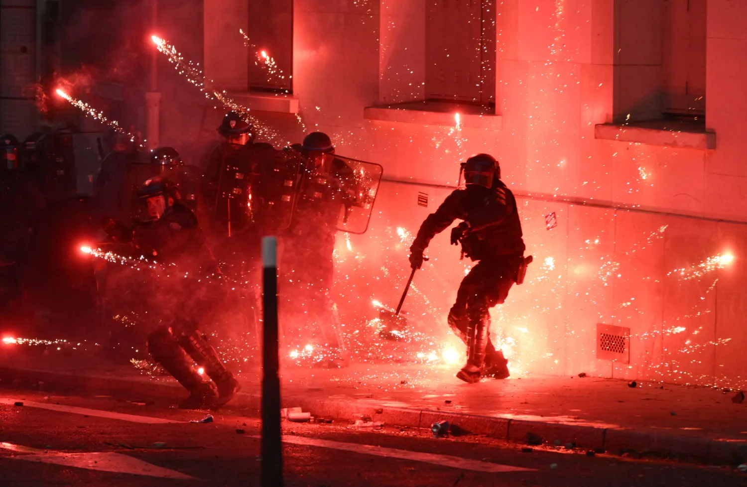 French riot police personnel are enveloped by fireworks during nationwide demonstrations over the rising cost of living and inequality organized by Yellow Vest movement, labor unions and high school and university students, in Paris on October 31, 2026. (AFP) 