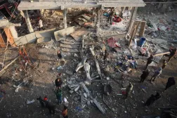 Palestinians check the damage outside a building targeted by an Israeli air strike early on December 12, 2024 near the Nuseirat refugee in the central Gaza Strip, amid the continuing war between Israel and Hamas. (Photo by Eyad BABA / AFP)