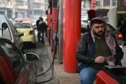 A man counts money at a gas station in Aleppo, northern Syria (AFP)