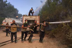 The Syrian Civil Defense, also known as the White Helmets, work to extinguish a wildfire, in Latakia countryside, Syria, July 6, 2025. REUTERS/Karam al-Masri