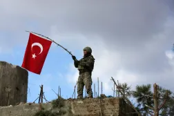 A Turkish soldier waves a flag on Mount Barsaya, northeast of Afrin, Syria January 28 ,2018. REUTERS/ Khalil Ashawi/File Photo