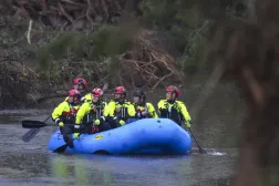 Yetkililer, Teksas'taki Guadalupe Nehri boyunca uzanan Camp Mystic'teki kurtarma çalışmalarına yardım etmek üzere bir bota biniyor (AP)