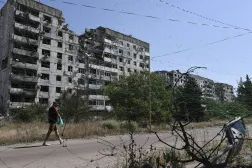 In this photo provided by Ukraine's 65th Mechanized Brigade press service, a local resident walks along the street under an anti-drone net in Orikhiv, Zaporizhzhia region, Ukraine, Tuesday, July 15, 2025. (Andriy Andriyenko/Ukraine's 65th Mechanized Brigade via AP) 