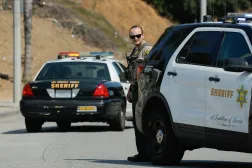 A Los Angeles County sheriff's officer stands watch as a police vehicle passes by, while officers block the road to the Los Angeles County Sheriff's Department's Biscailuz Center Academy Training facility,in East Los Angeles, California, US July 18, 2025. REUTERS/ Mike Blake