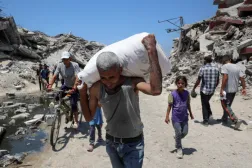 A Palestinian carries a bag with aid supplies that entered Gaza through Israel, in Beit Lahia, northern Gaza Strip, July 27. REUTERS/Mahmoud Issa 