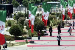 People walk next to Iranian national flags in a street in Tehran, Iran, 10 August 2025. (EPA)