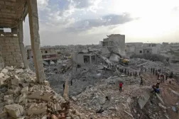 Syrians gather amidst destruction in Zardana, in the mostly rebel-held northern Syrian Idlib province, after airstrikes in the area late on June 8, 2018 | AFP
