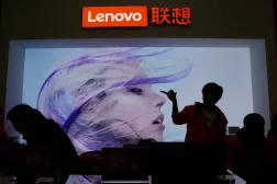 FILE PHOTO: An employee gestures next to a Lenovo logo at Lenovo Tech World in Beijing, China November 15, 2019. REUTERS/Jason Lee/File Photo