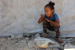 دختر فلسطینی دیروز در شهر غزه برنج پخته‌ای را که از یک آشپزخانه خیریه گرفته بود، می‌خورد (AFP)