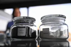 A glass jar containing the rare earth metal Terbium (L) is pictured inside the storage room of Tradium, a company specialised in trading rare earths, in Frankfurt am Main, western Germany, on November 4, 2025. (Photo by Kirill KUDRYAVTSEV / AFP)