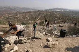 İşgal altındaki Batı Şeria'da, Nablus'un doğusunda yerleşimcilerin topraklarına el koymasını protesto eden Filistinliler, dün İsrail ordusunun attığı gaz bombalarından kaçıyor (AFP)